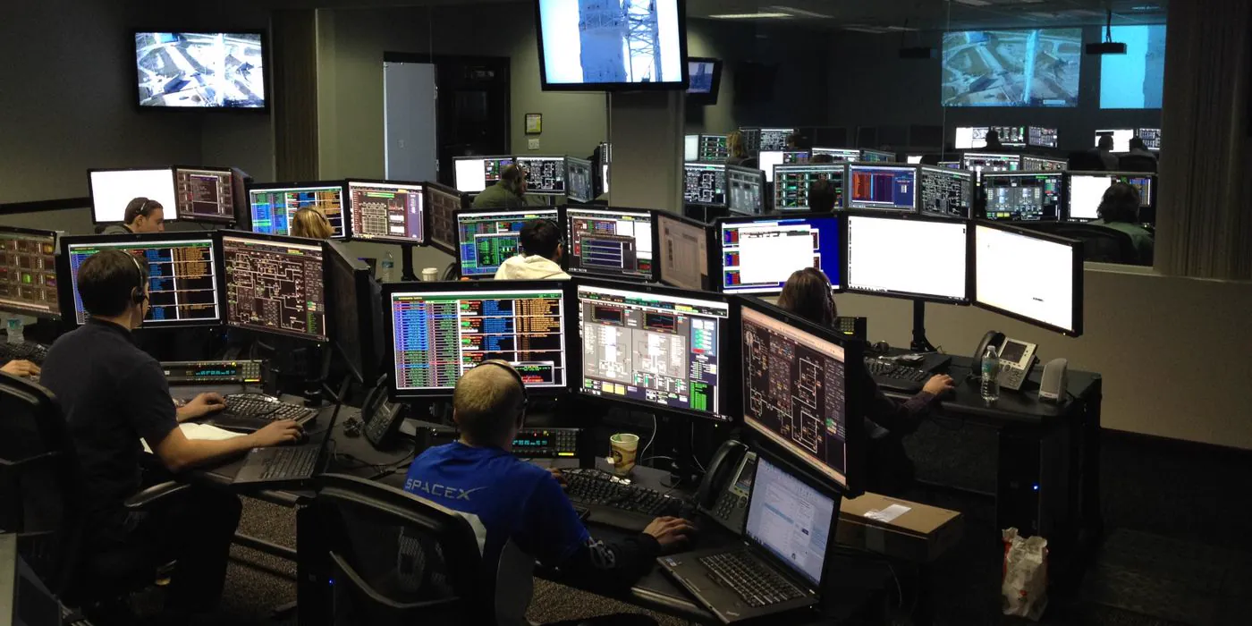 Operators monitoring systems across banks of screens in an operations centre