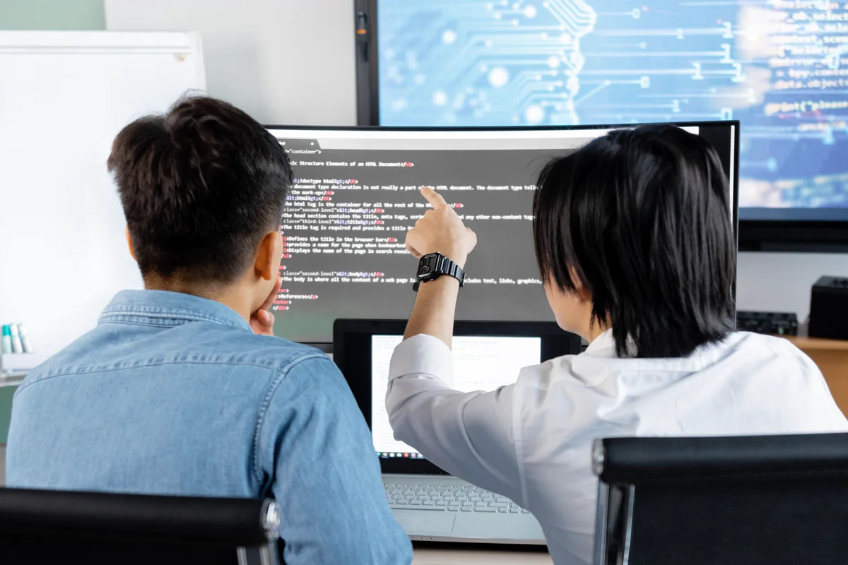 Two engineers reviewing code together on screen during a pairing session